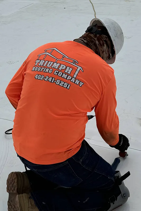 Back of shirt of Triumph Roofing Company employee